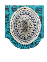 Bolso de piel de potro con solapa azul turquesa. Rodeado de piedras naturales turquesas blancas