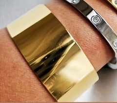 Wide golden stainless steel bracelet.