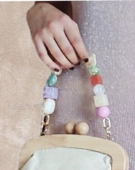 CLUTCH MENORCA. Bolso vegetal con tono ligeramente dorado y asas de madera. Lleva cadenita larga que puede sustituirse por otras decorativas.