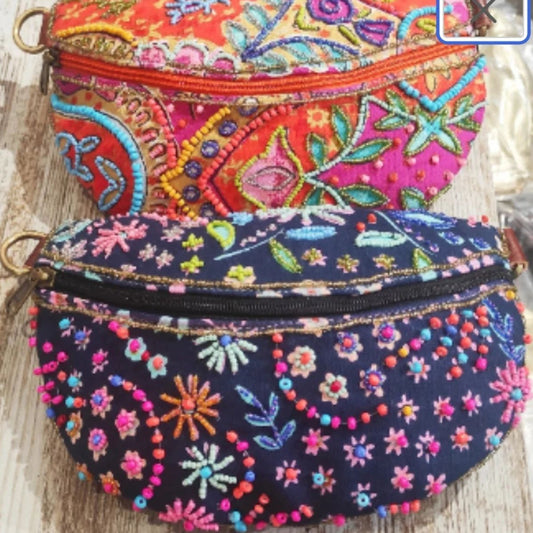 Riñonera de algodón de color azul. Bordada sobre el estampado de flore