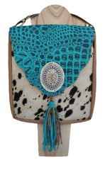 Pony skin bag with turquoise blue flap. Surrounded by white turquoise natural stones