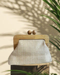 CLUTCH MENORCA. Bolso vegetal con tono ligeramente dorado y asas de madera. Lleva cadenita larga que puede sustituirse por otras decorativas.