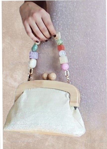 CLUTCH MENORCA. Bolso vegetal con tono ligeramente dorado y asas de madera. Lleva cadenita larga que puede sustituirse por otras decorativas.